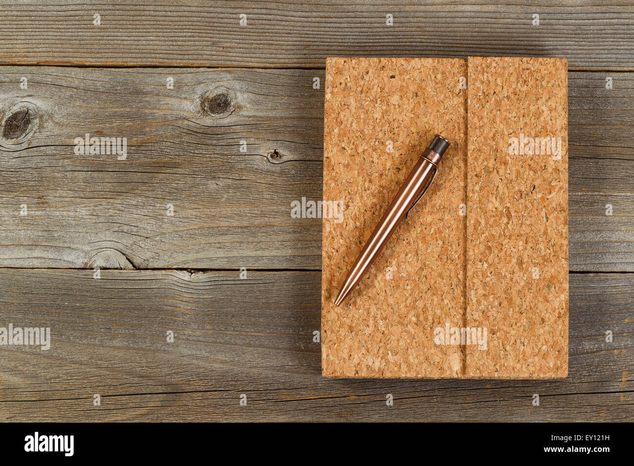 Vintage Penna in metallo e sughero coperto notepad sul legno rustico desktop. Foto Stock