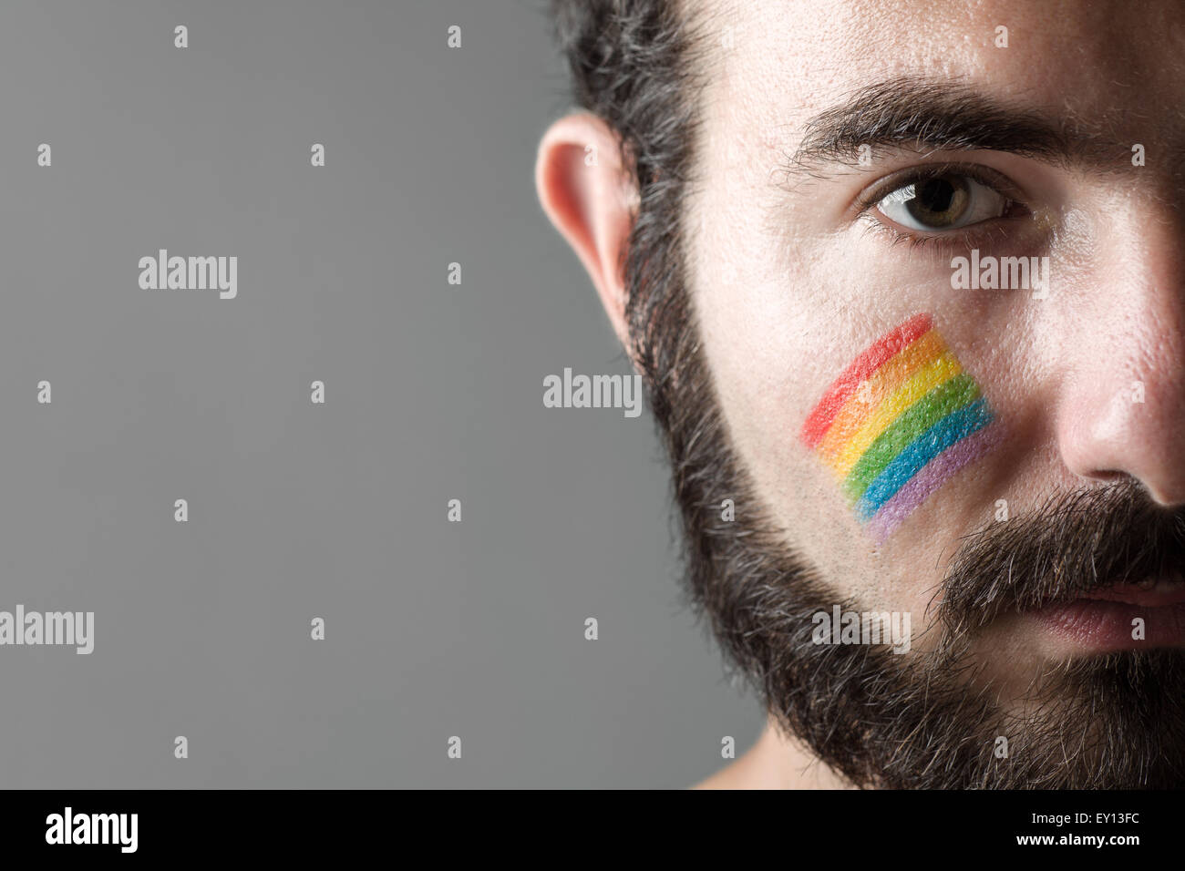 Uomo con Rainbow dipinta sulla sua guancia, simbolo dei diritti dei gay Foto Stock