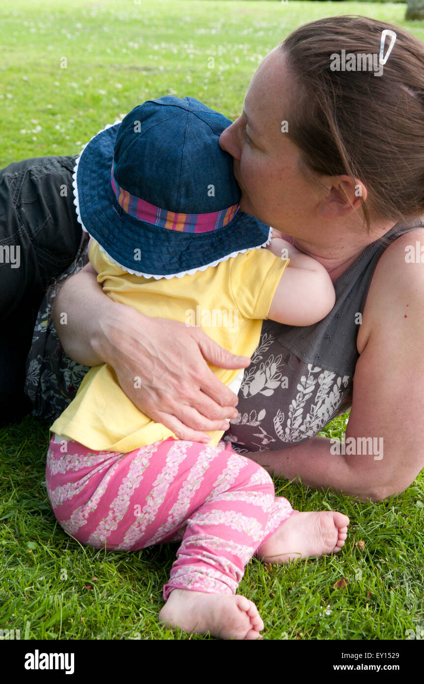 Madre consolante la sua bambina nel giardino Foto Stock