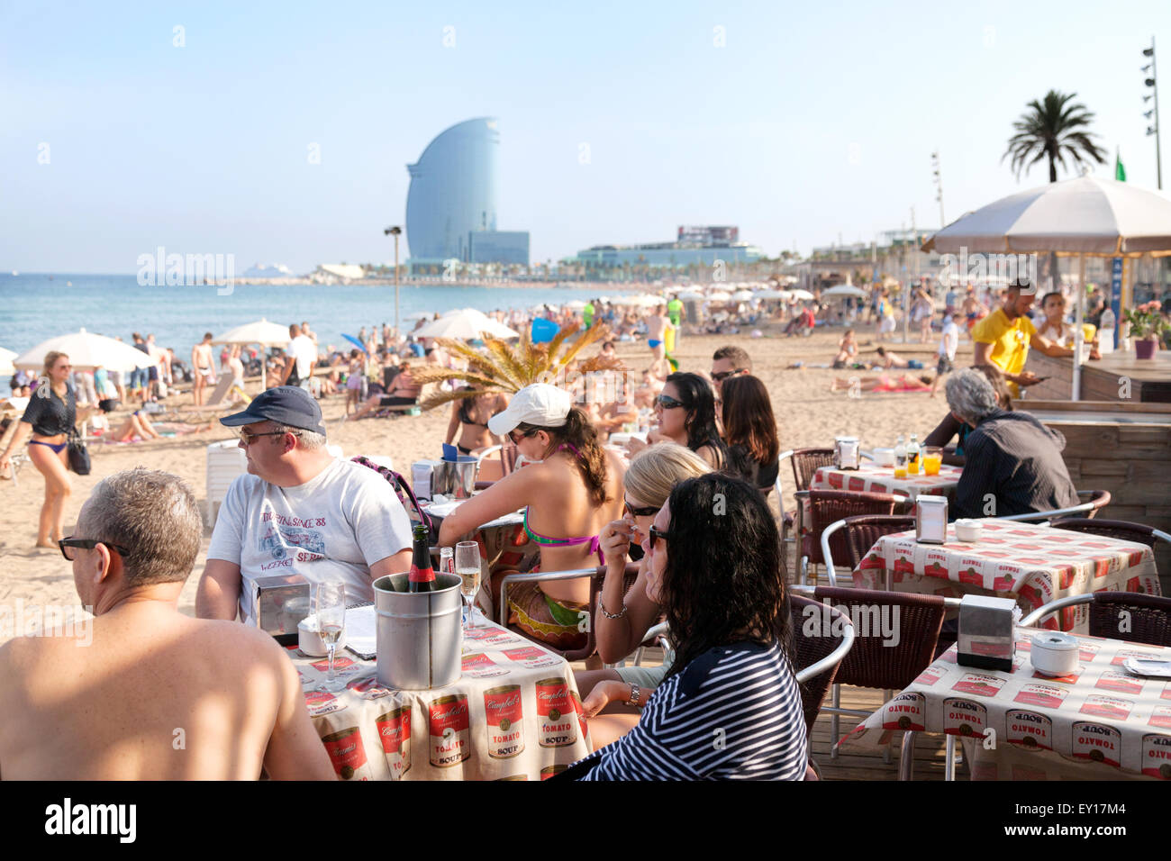 La gente seduta a un bar sulla spiaggia cafe, Platya de la Barceloneta ( Barceloneta Beach ), Barcelona, Spagna Europa Foto Stock