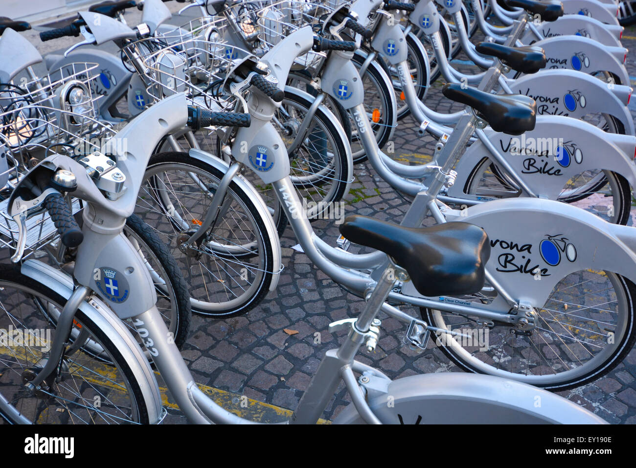 Una fila o biciclette a noleggio in un Verona Stazione bike, Italia Foto Stock