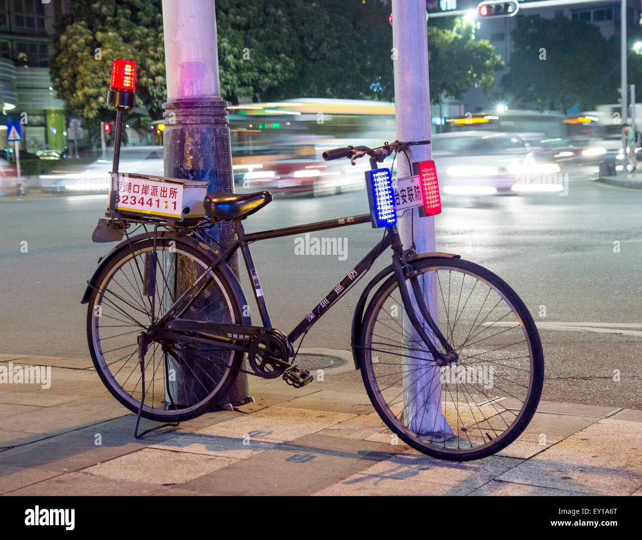 La polizia in bicicletta sulla strada all'incrocio nel centro della città di notte Foto Stock