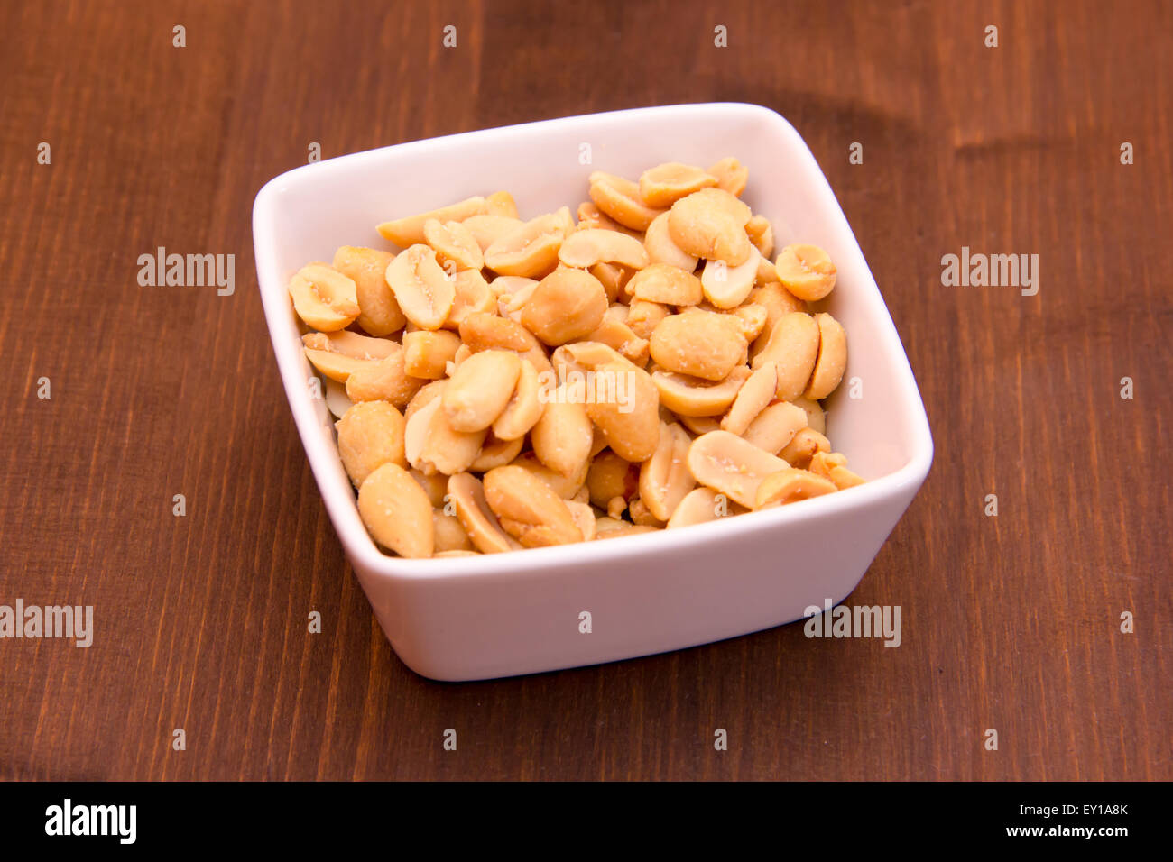 I dadi salati sulla ciotola su legno Foto Stock