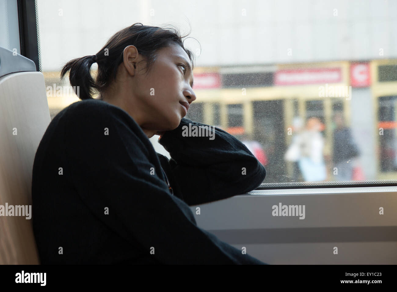 Malinconica donna guarda fuori dalla finestra del tram Foto Stock