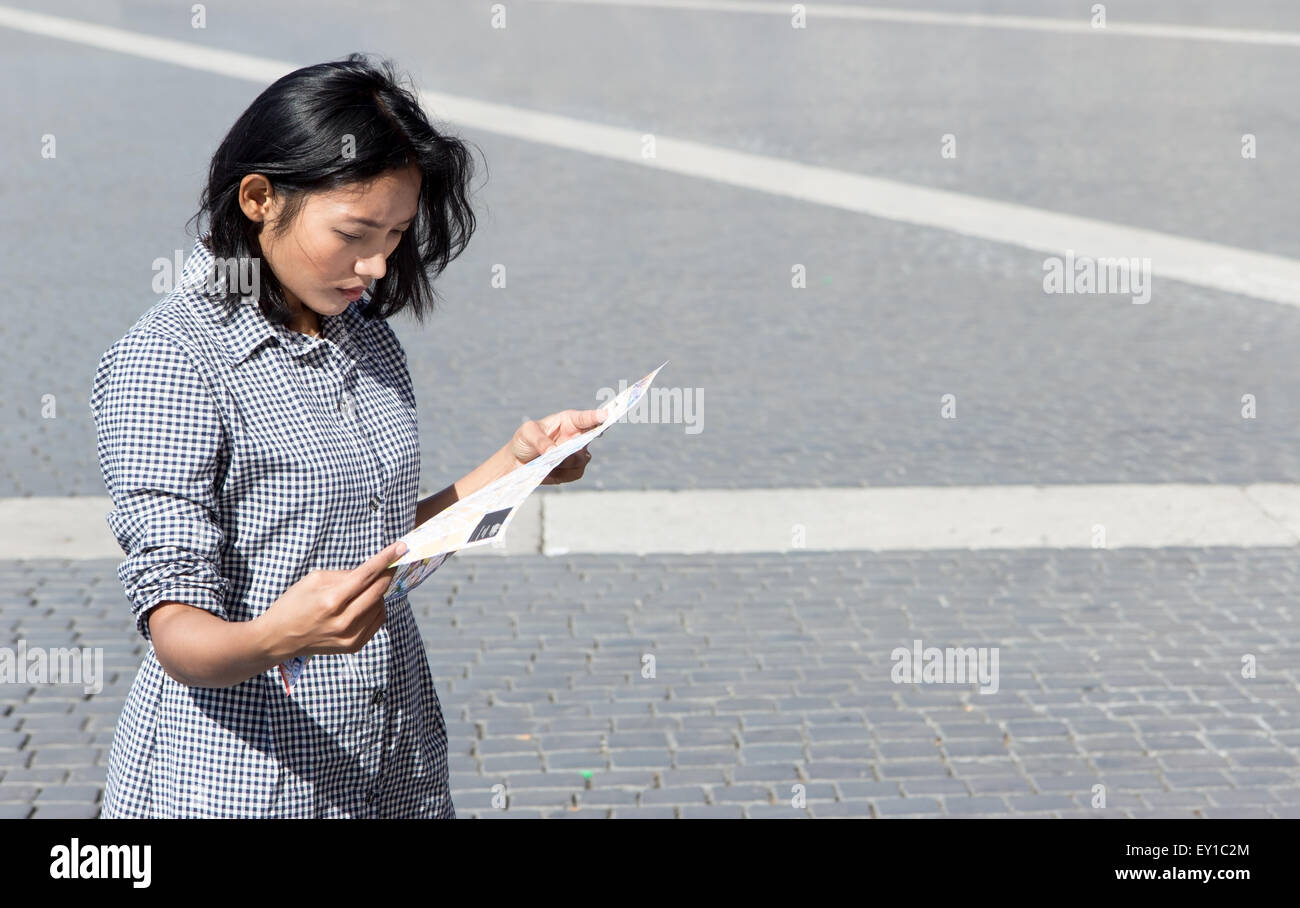 La donna lo studio di una mappa della città in piazza Foto Stock