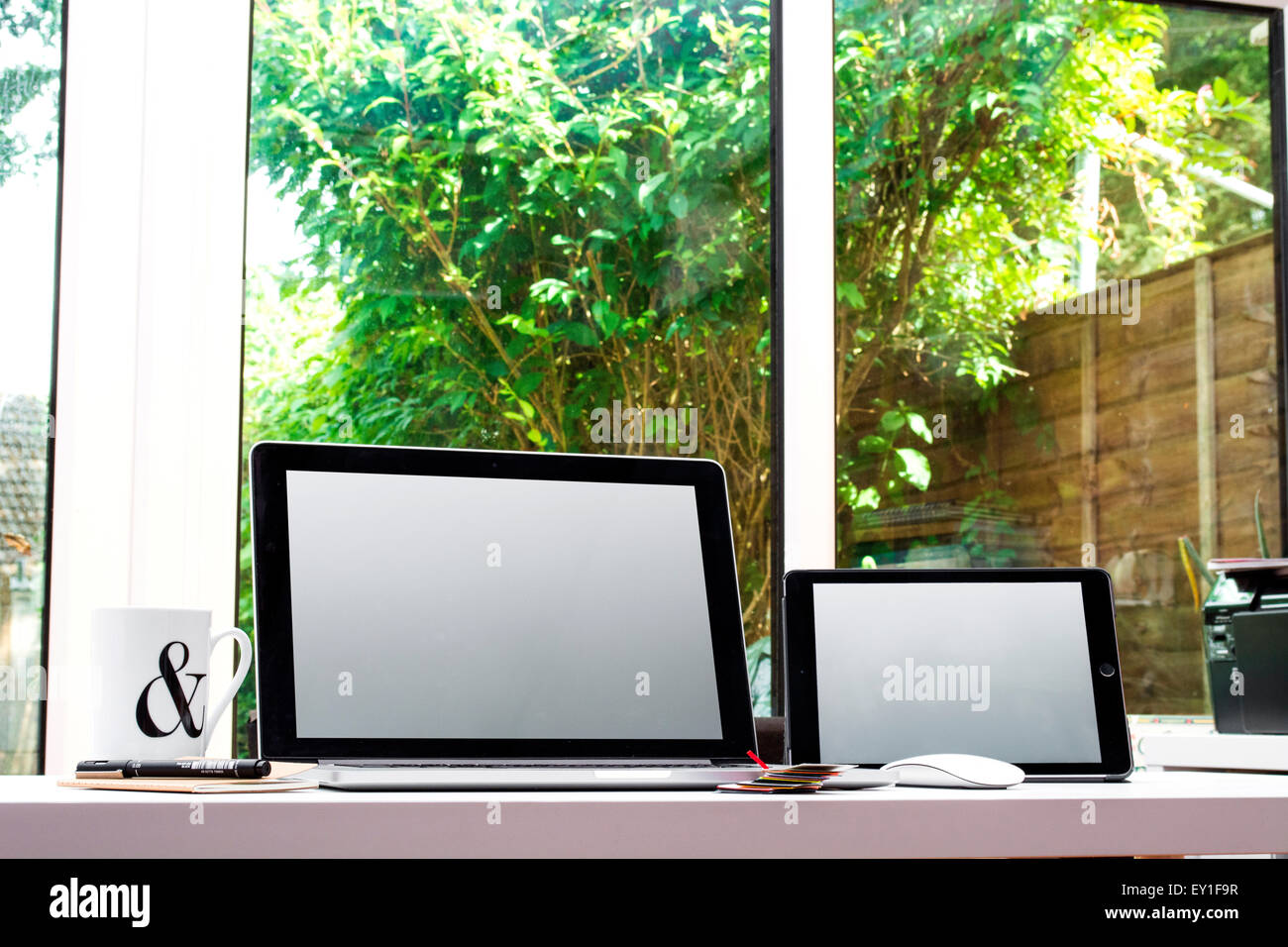 Creative Home Office space con progettisti grafici scrivania con computer portatile lookin gotta una finestra Foto Stock