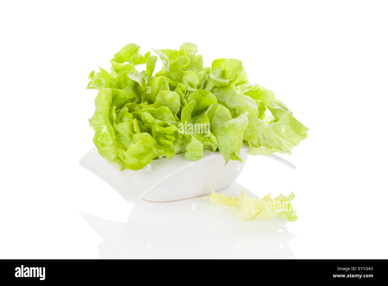 Fresca insalata verde nella ciotola bianco isolato su sfondo bianco. Fresco e salutare mangiare d'estate. Arte culinaria. Moderna immagine minimale Foto Stock