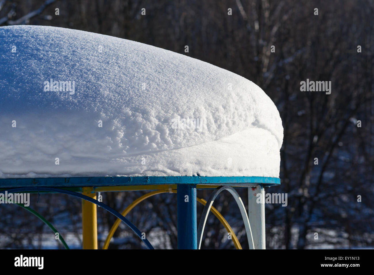 Coperta di neve tetto di un padiglione del parco nella soleggiata giornata invernale Foto Stock
