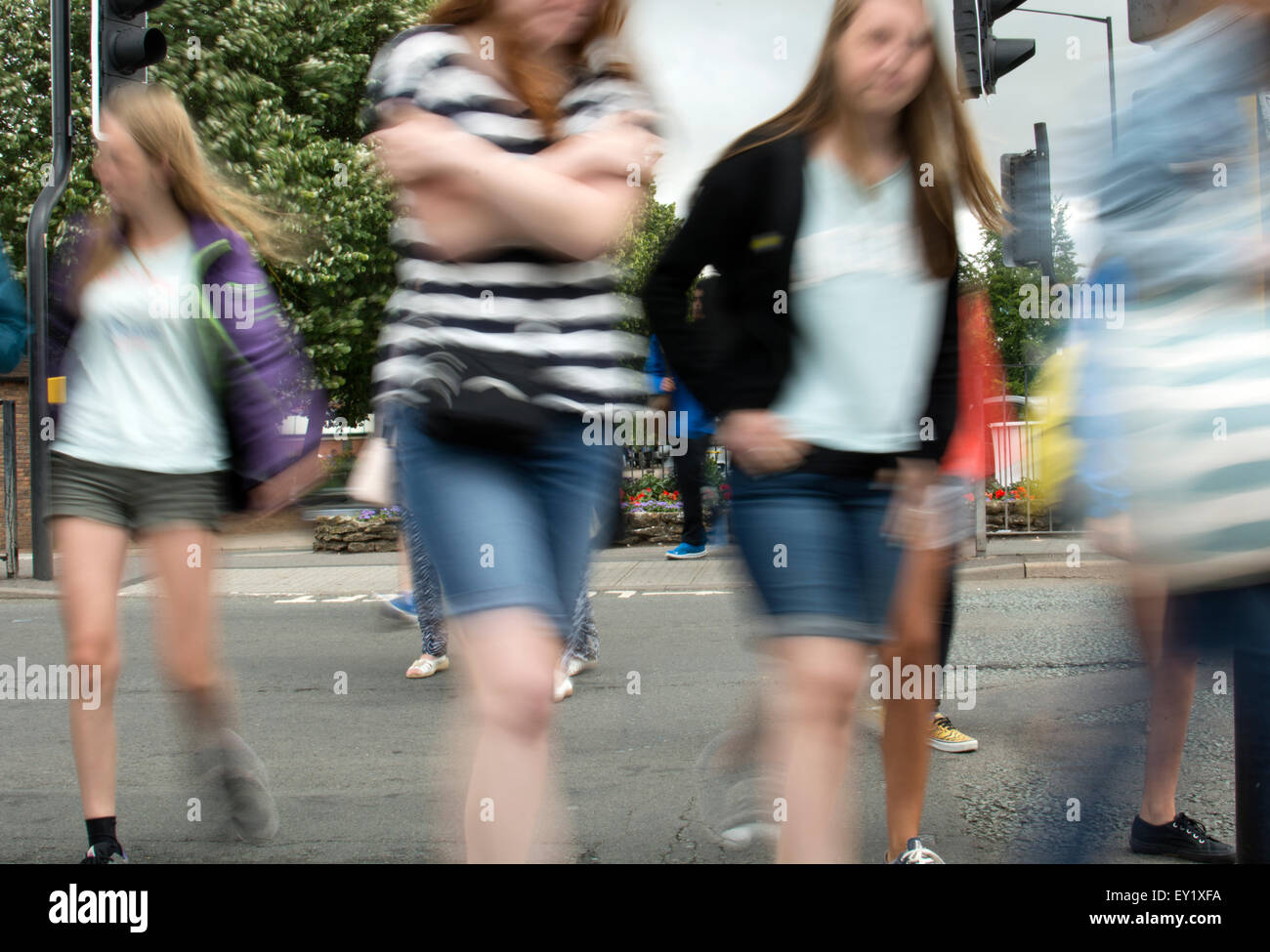 Le ragazze adolescenti attraversare una strada, motion blur, REGNO UNITO Foto Stock