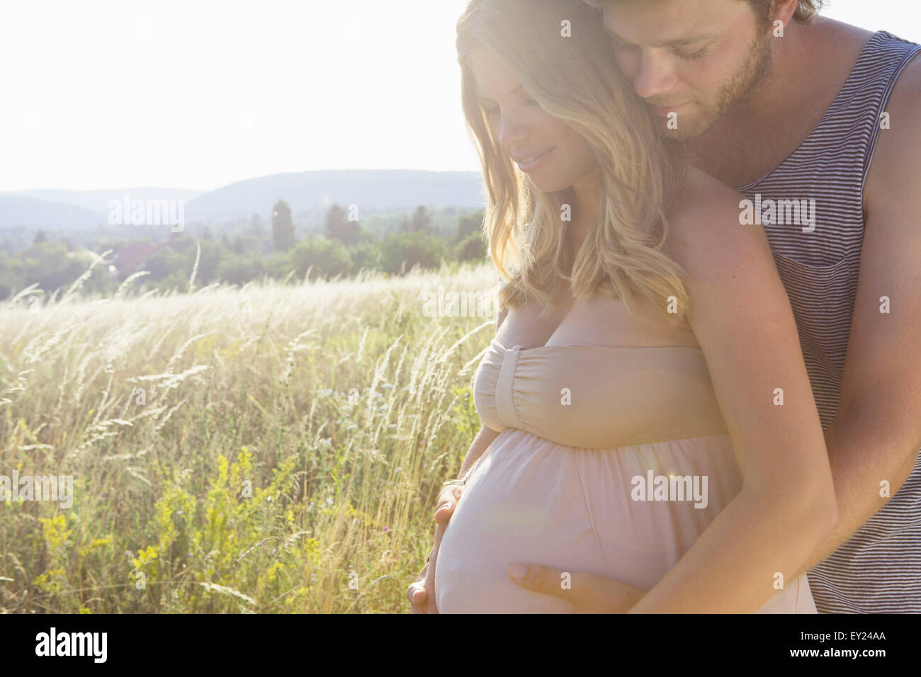 Giovane uomo toccando gravidanza stomaco fidanzate nel campo Foto Stock