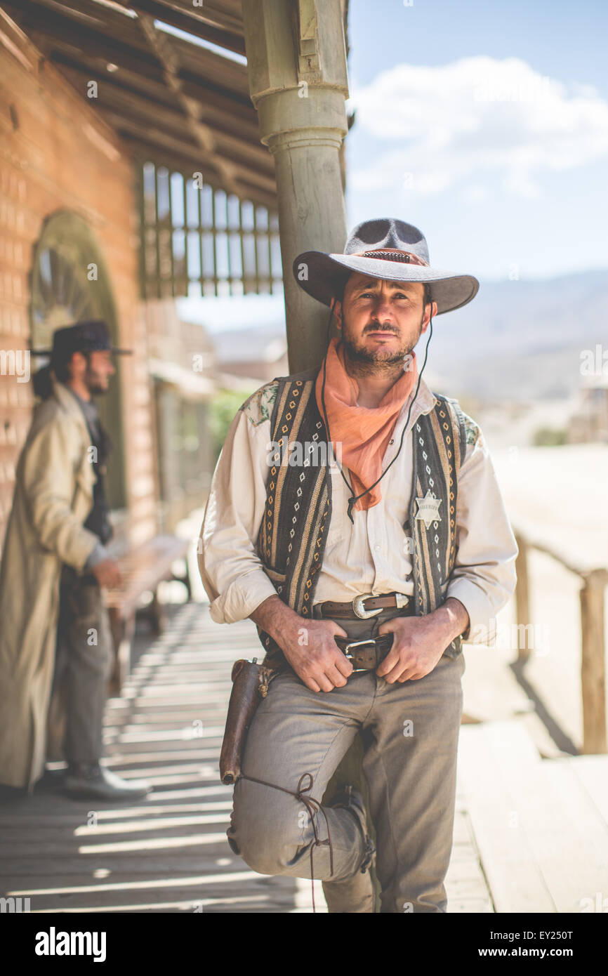 Ritratto di cowboy appoggiata contro il pilastro sul selvaggio west set cinematografico, Fort Bravo, Tabernas, Almeria, Spagna Foto Stock