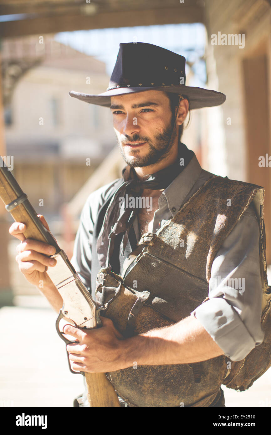 Cowboy mantenendo la doppietta sul selvaggio west set cinematografico, Fort Bravo, Tabernas, Almeria, Spagna Foto Stock