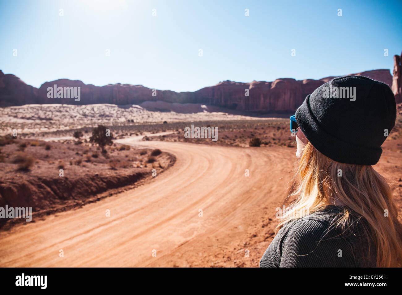 Metà donna adulta guardando fuori in ambito rurale su strada sterrata, Monument Valley, Utah, Stati Uniti d'America Foto Stock