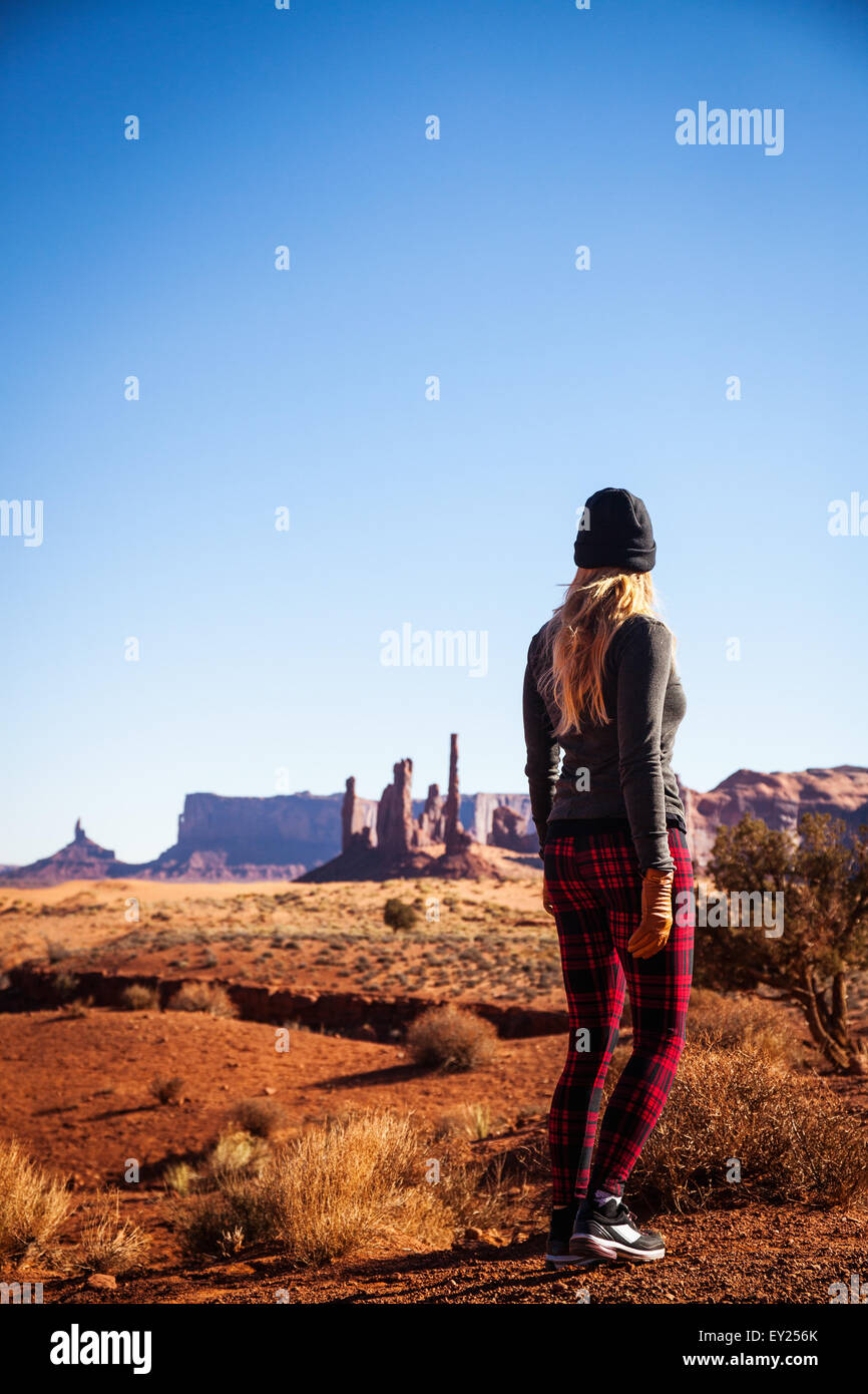 Vista posteriore della metà donna adulta, guardando dalla Monument Valley, Utah, Stati Uniti d'America Foto Stock