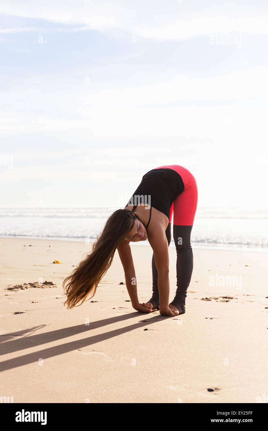 Donna in posa yoga sulla spiaggia Foto Stock