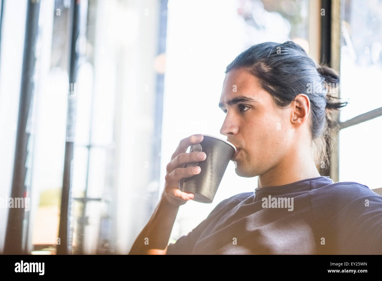 Giovane uomo di bere il caffè, in interni Foto Stock