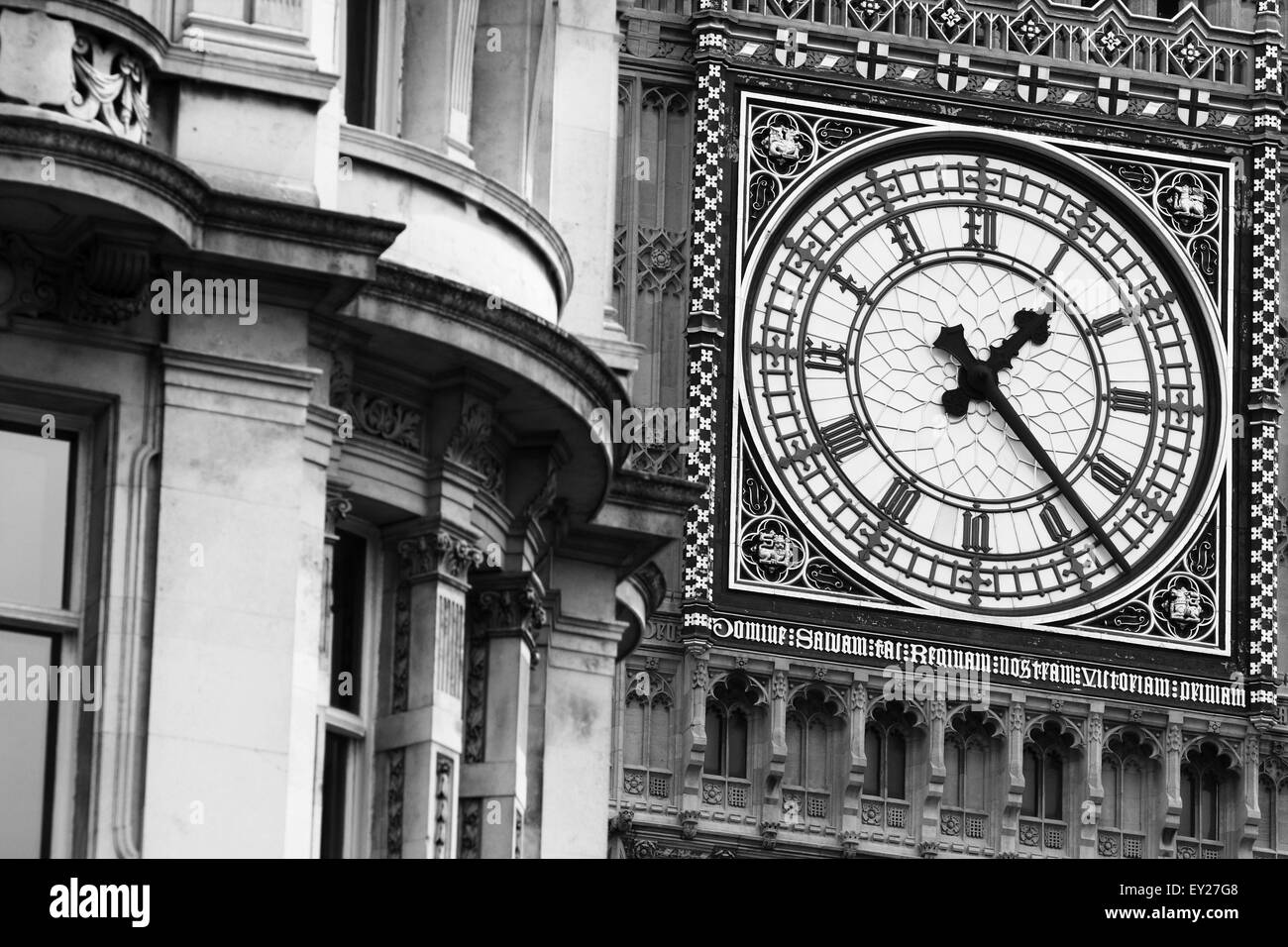 Una vista di una faccia del Big Ben con un edificio ad angolo del Parlamento Street in primo piano. Foto Stock