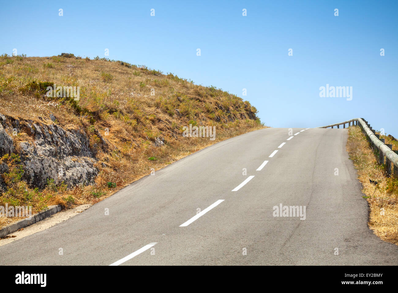Montagna vuota strada asfaltata e cielo blu Foto Stock