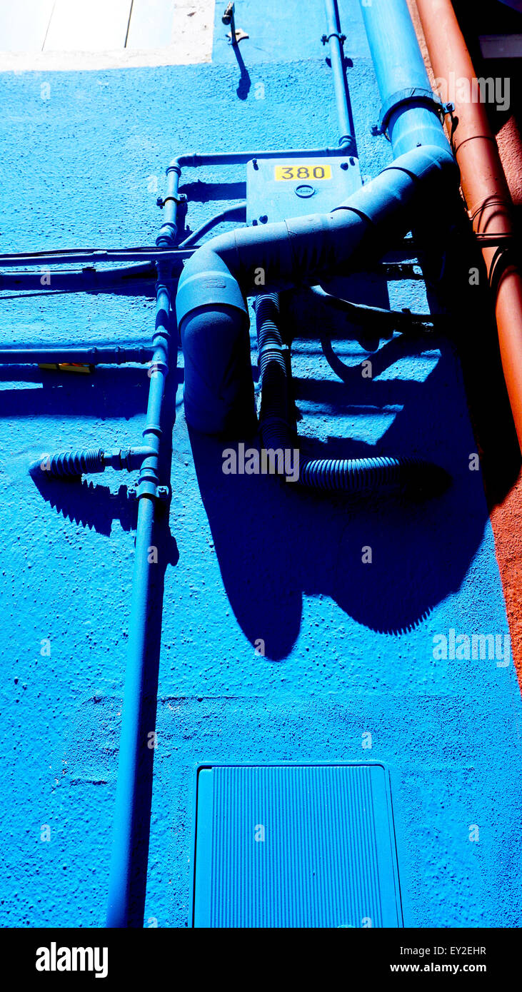 Tubo di metallo e cassetta elettrica sul colore blu nella parete di Burano Venezia Italia Foto Stock