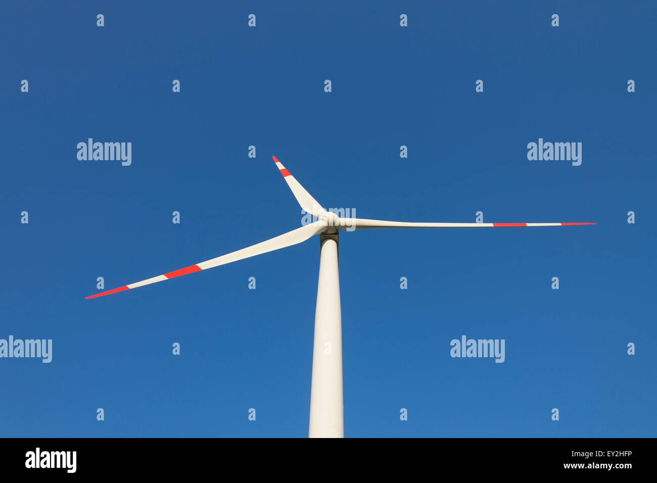 Il worm-eye vista sulle pale del rotore della turbina eolica contro il cielo blu Foto Stock