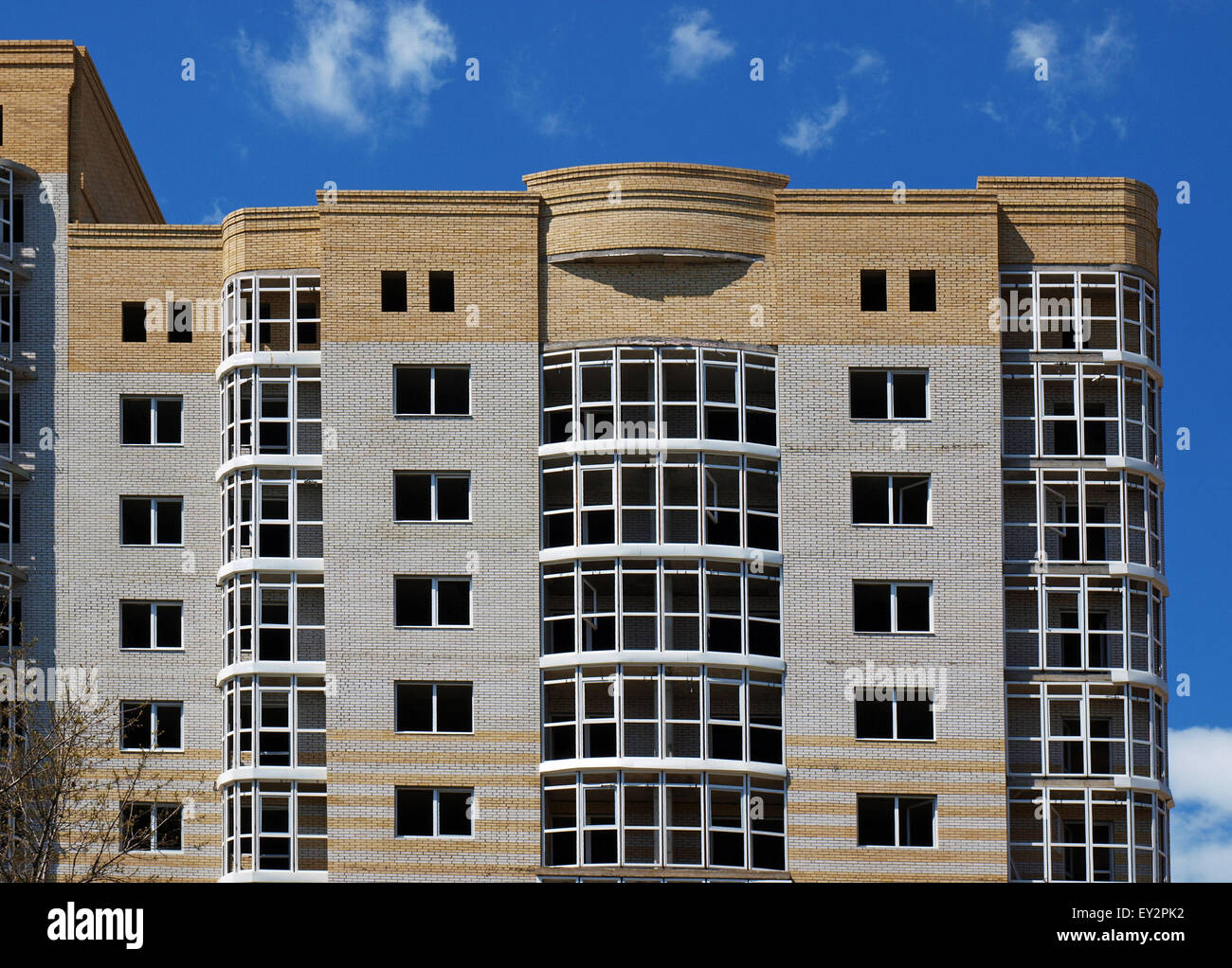 I piani superiori dell'edificio multipiano contro il cielo blu con nuvole Foto Stock