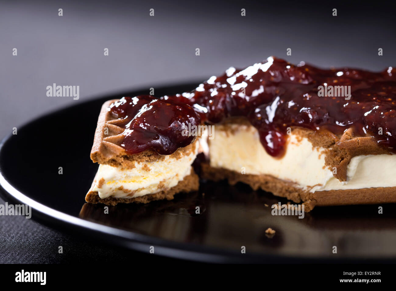 Ice Cream Sandwich con confettura di fragole su una piastra scuro Foto Stock