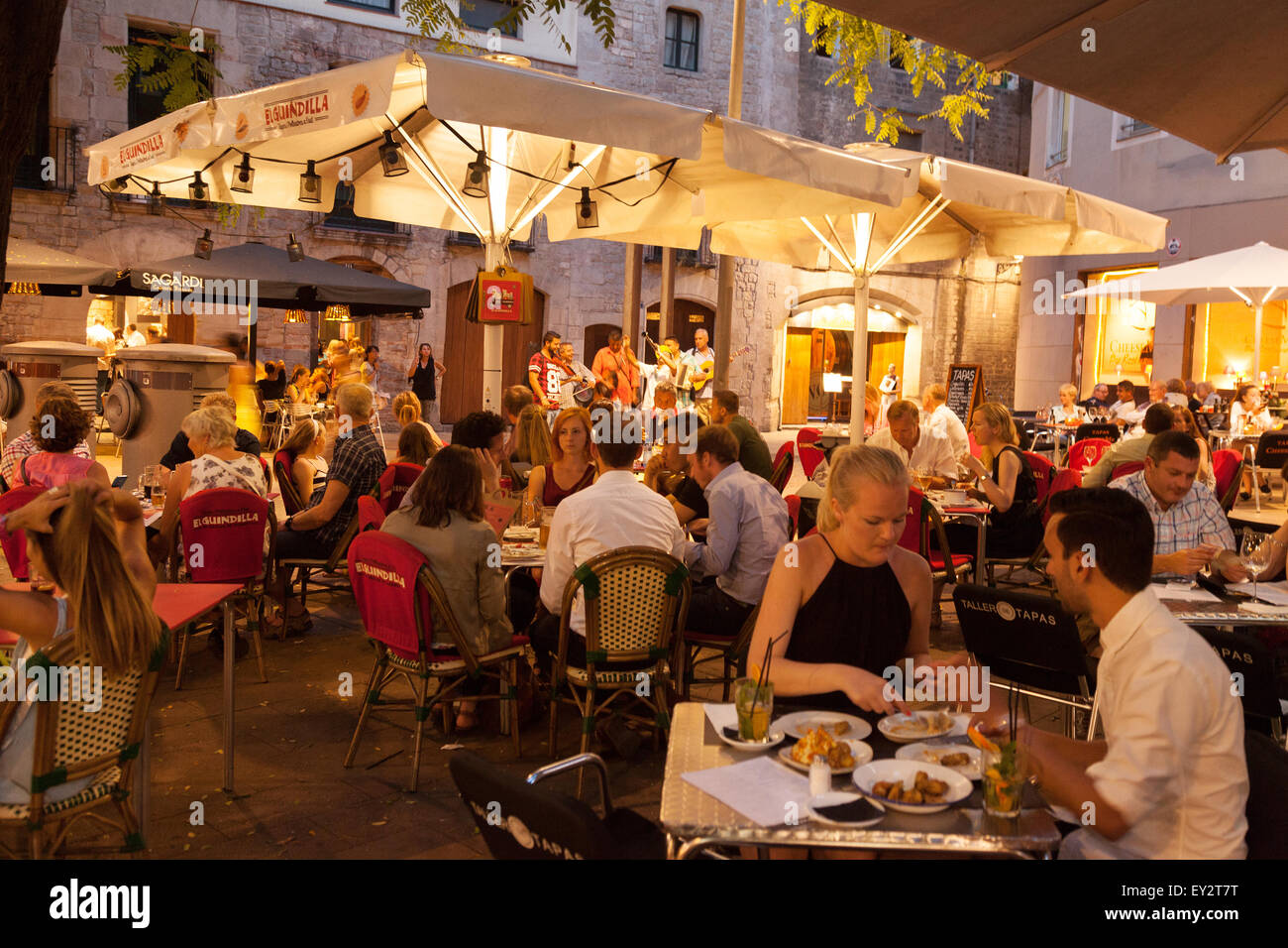 La gente del posto e turisti di mangiare in un ristorante al di fuori di notte, Barceloneta, Barcelona, Spagna Europa Foto Stock