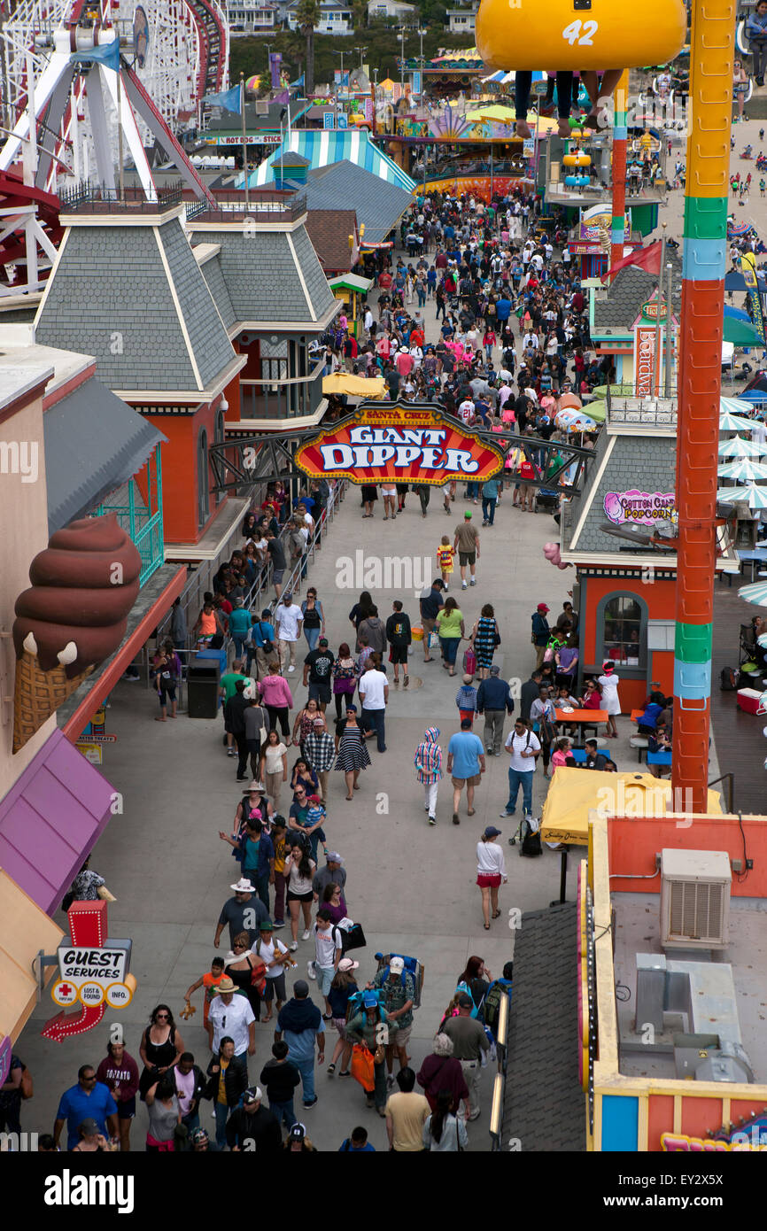 Una folla di gente che passeggia sotto il gigante del bilanciere linea ride, Santa Cruz Boardwalk, Santa Cruz, in California, Stati Uniti d'America Foto Stock
