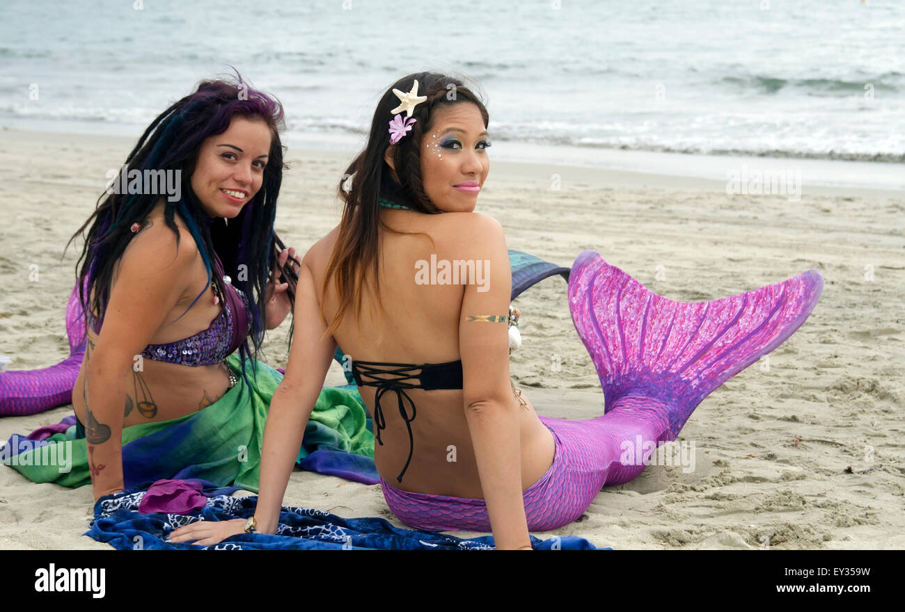 Due donne in costumi mermaid in posa sulla spiaggia Foto Stock