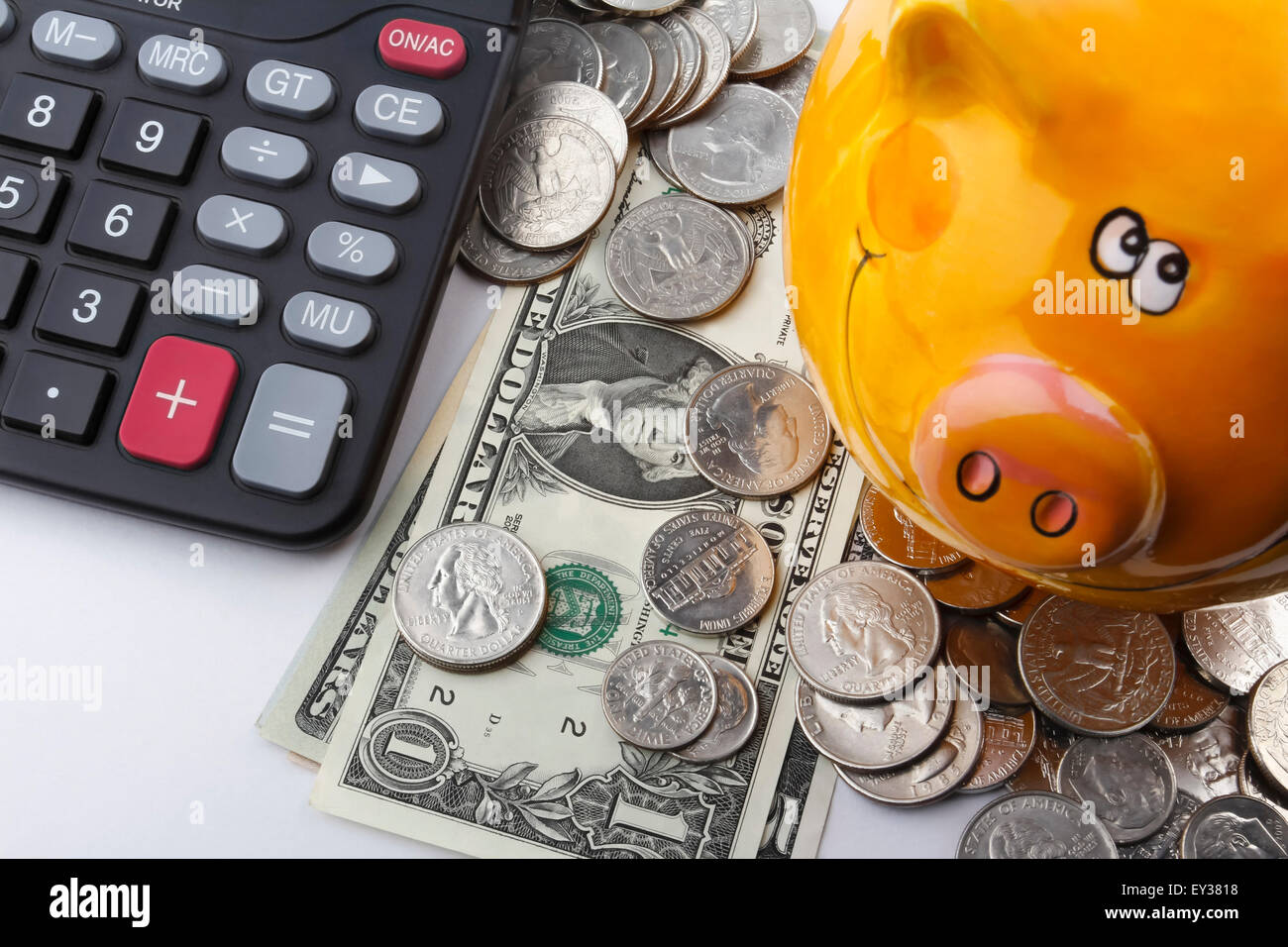 Dollaro delle monete e delle banconote, insieme con un salvadanaio e calcolatrice. Foto Stock