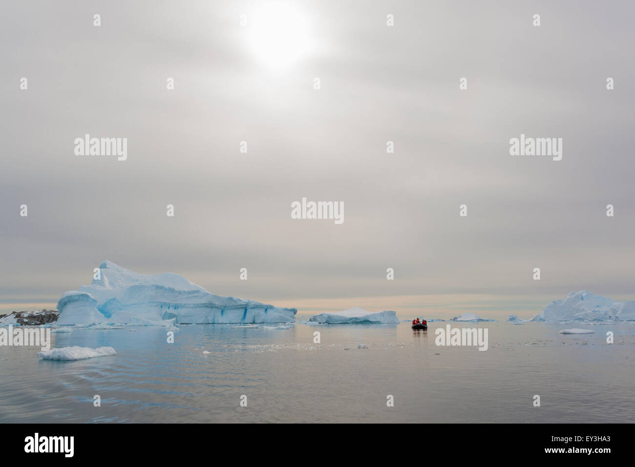 Vista di un gruppo di persone in una barca di gomma vicino e iceberg in Antartide. Foto Stock