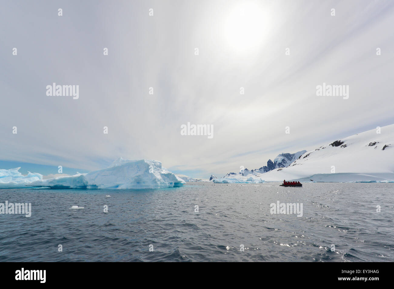 Vista di un gruppo di persone in una barca di gomma nei pressi di un iceberg offshore nell'Antartico. Foto Stock