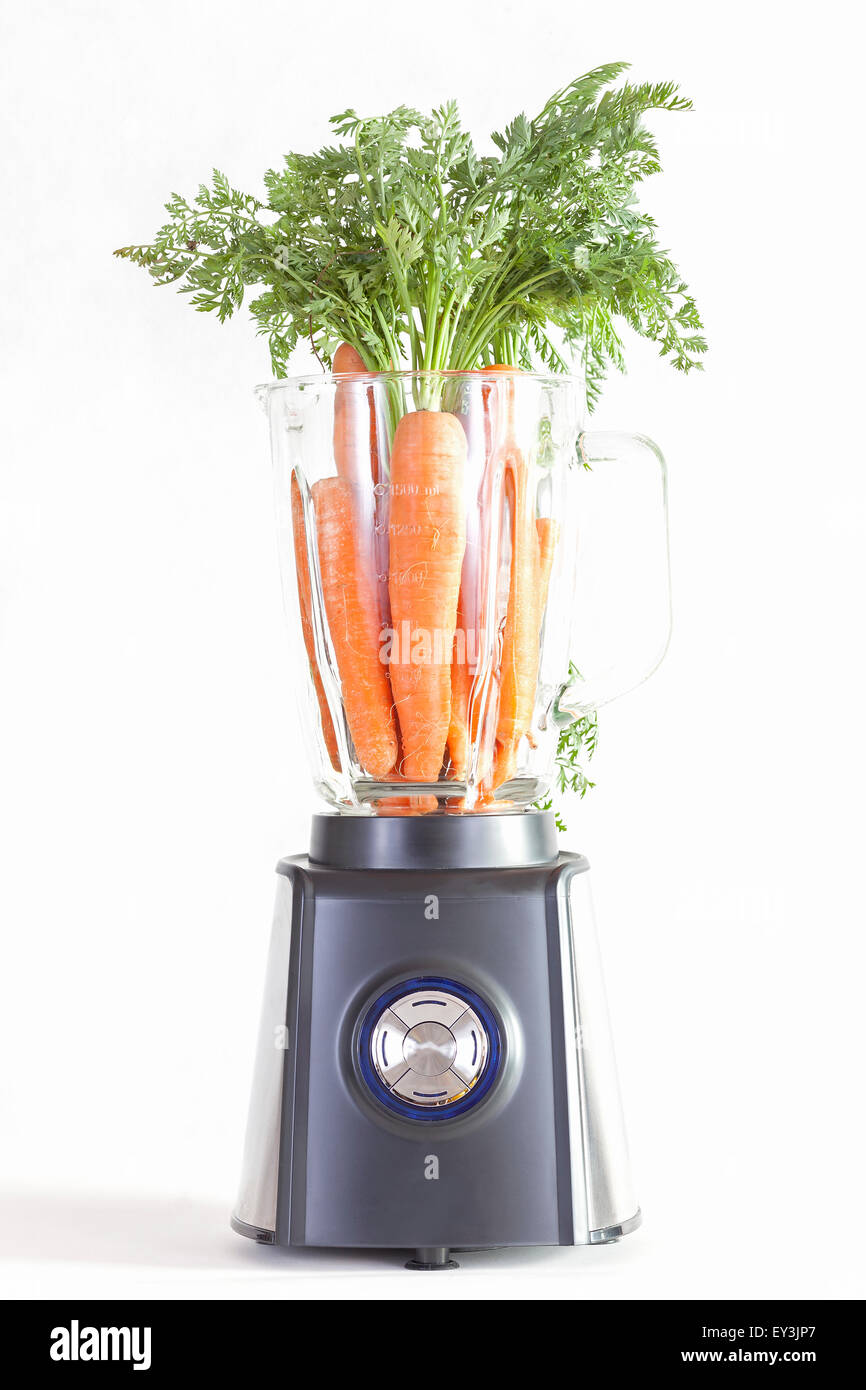 Frullatore elettrico con carote su uno sfondo bianco. Foto Stock