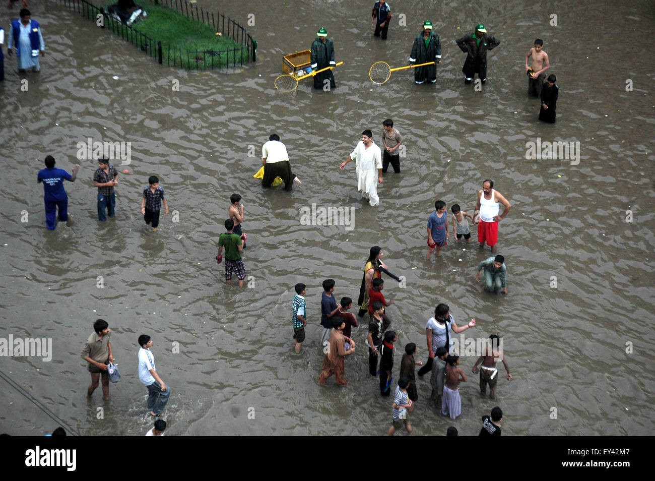 Lahore. 21 Luglio, 2015. Persone wade in una strada allagata dopo forti piogge monsoniche in Pakistan orientale di Lahore, il 21 luglio 2015. Heavy Rain in diverse parti del Pakistan disturbati di volo e gli orari del treno, i media locali hanno riferito. Credito: Sajjad/Xinhua/Alamy Live News Foto Stock