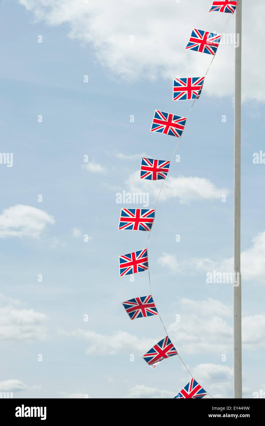 Union Jack flag bunting su una bandiera pole contro un cielo blu Foto Stock
