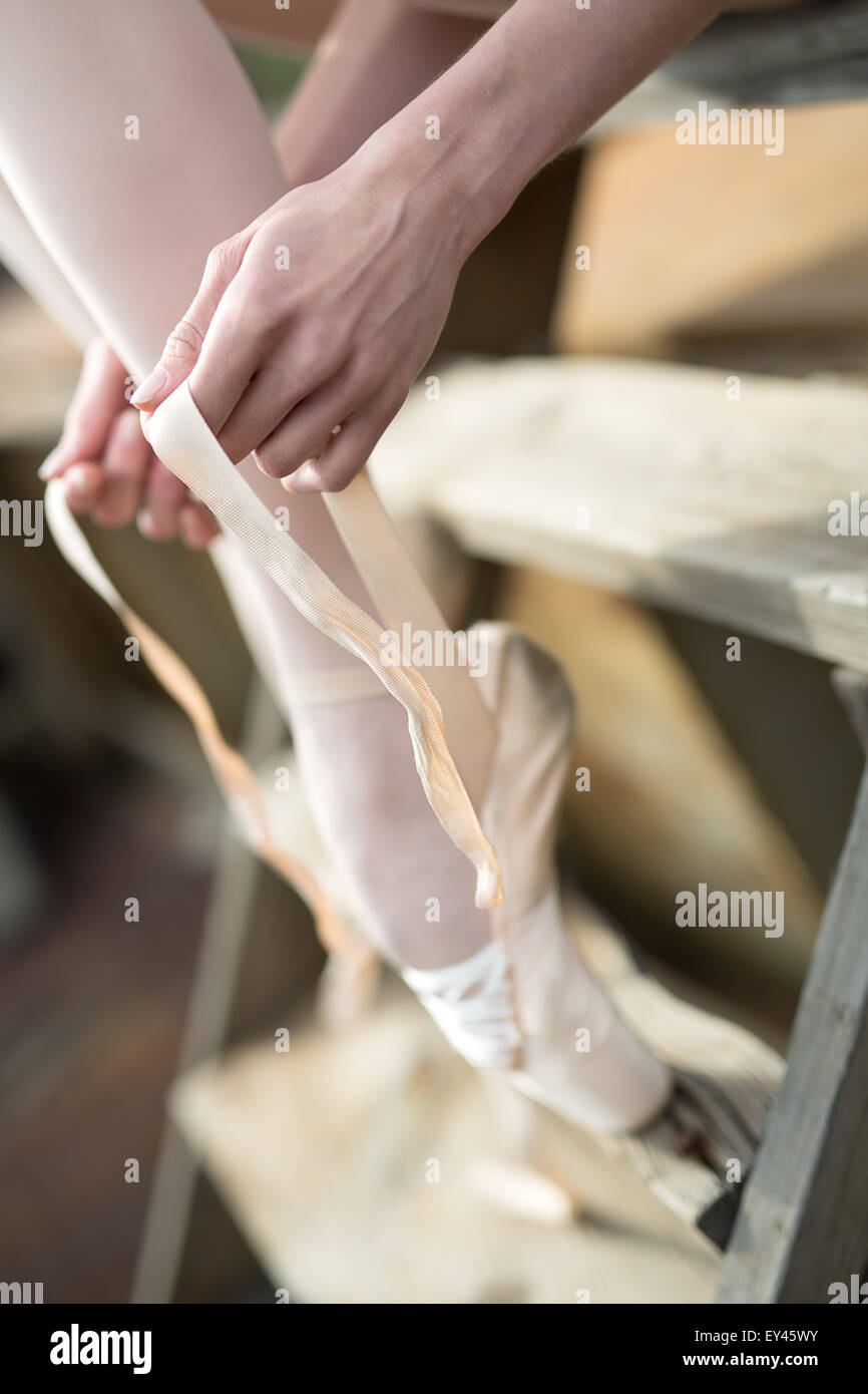 Ballerina di legatura del nastro sul suo white pointe Foto Stock