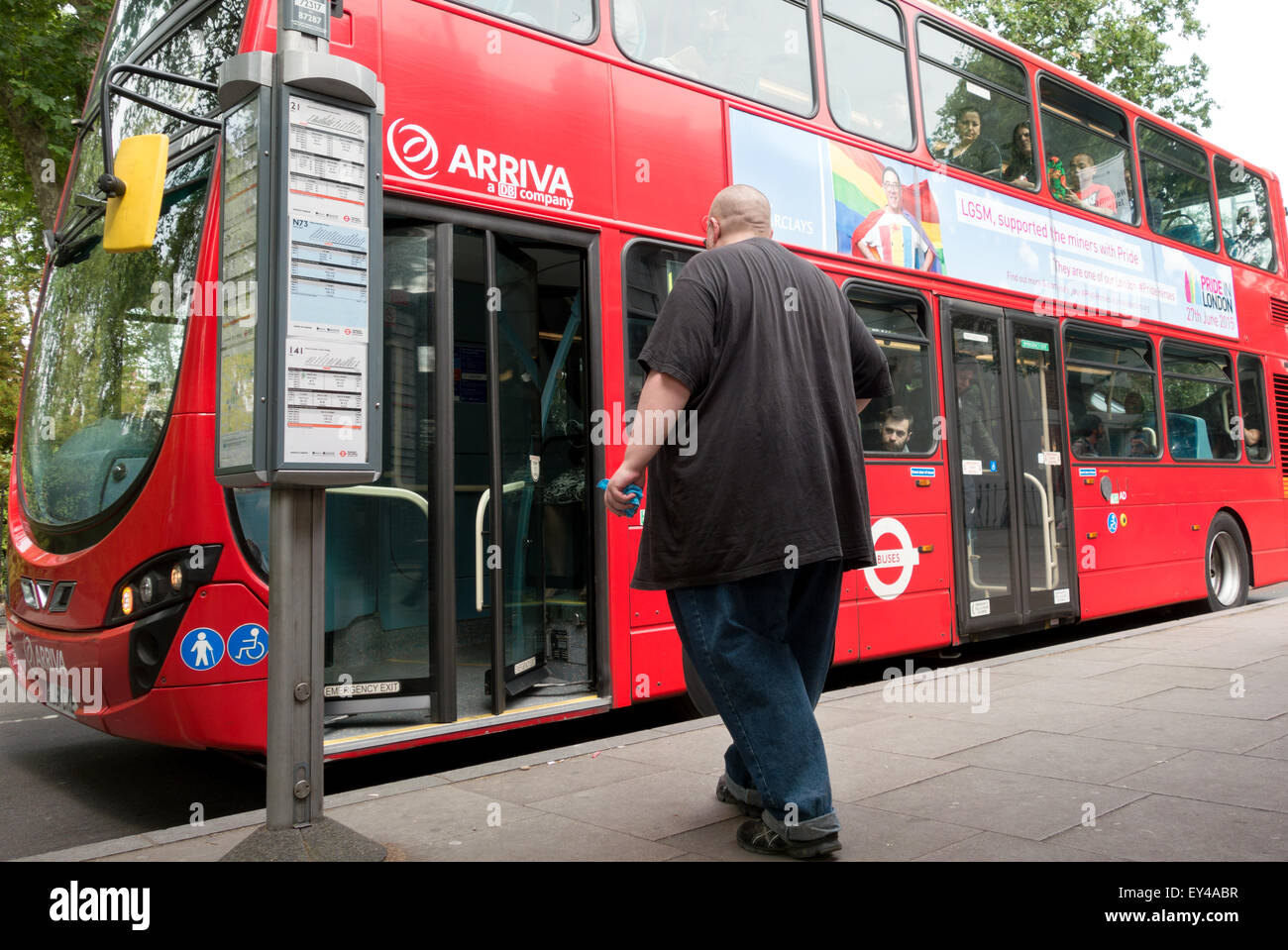 Obeso di salire a bordo di un autobus di Londra a una fermata degli autobus di Londra, Inghilterra REGNO UNITO Foto Stock