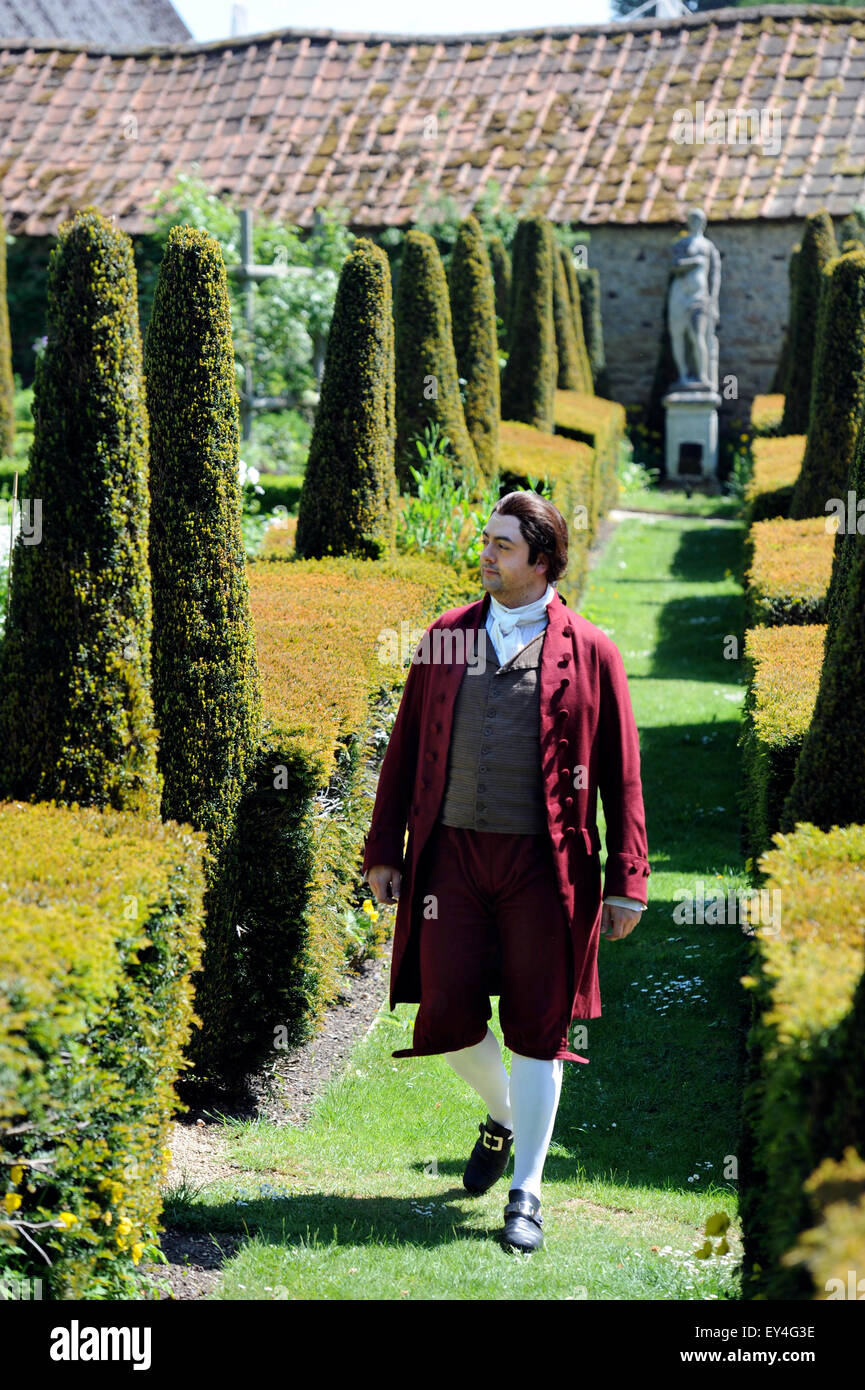 Un cantante di opera passeggiate attraverso il parterre garden a Garsington Manor, Oxfordshire, Regno Unito Foto Stock