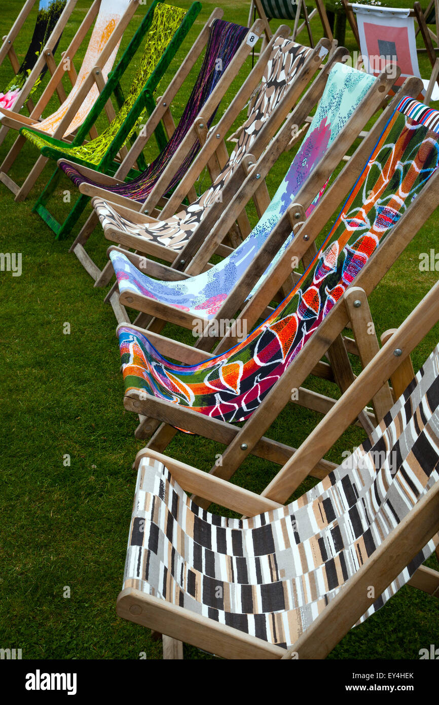 Posto a sedere in giardino floreale al Tatton Park, Cheshire, Regno Unito, 21 luglio 2015. Manchester School of Art, con la loro mostra, a motivi geometrici, telaio in legno pieghevole Classic Deck Chair Artschool; Summer Lawn sdraio a righe, al RHS Flower Show. Ogni sedia a sdraio è stata ridisegnata individualmente e ricreata da artisti e designer della Manchester School of Art Foto Stock