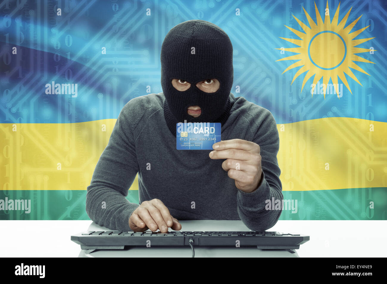 Di carnagione scura hacker con carta di credito e bandiera su sfondo - Rwanda Foto Stock