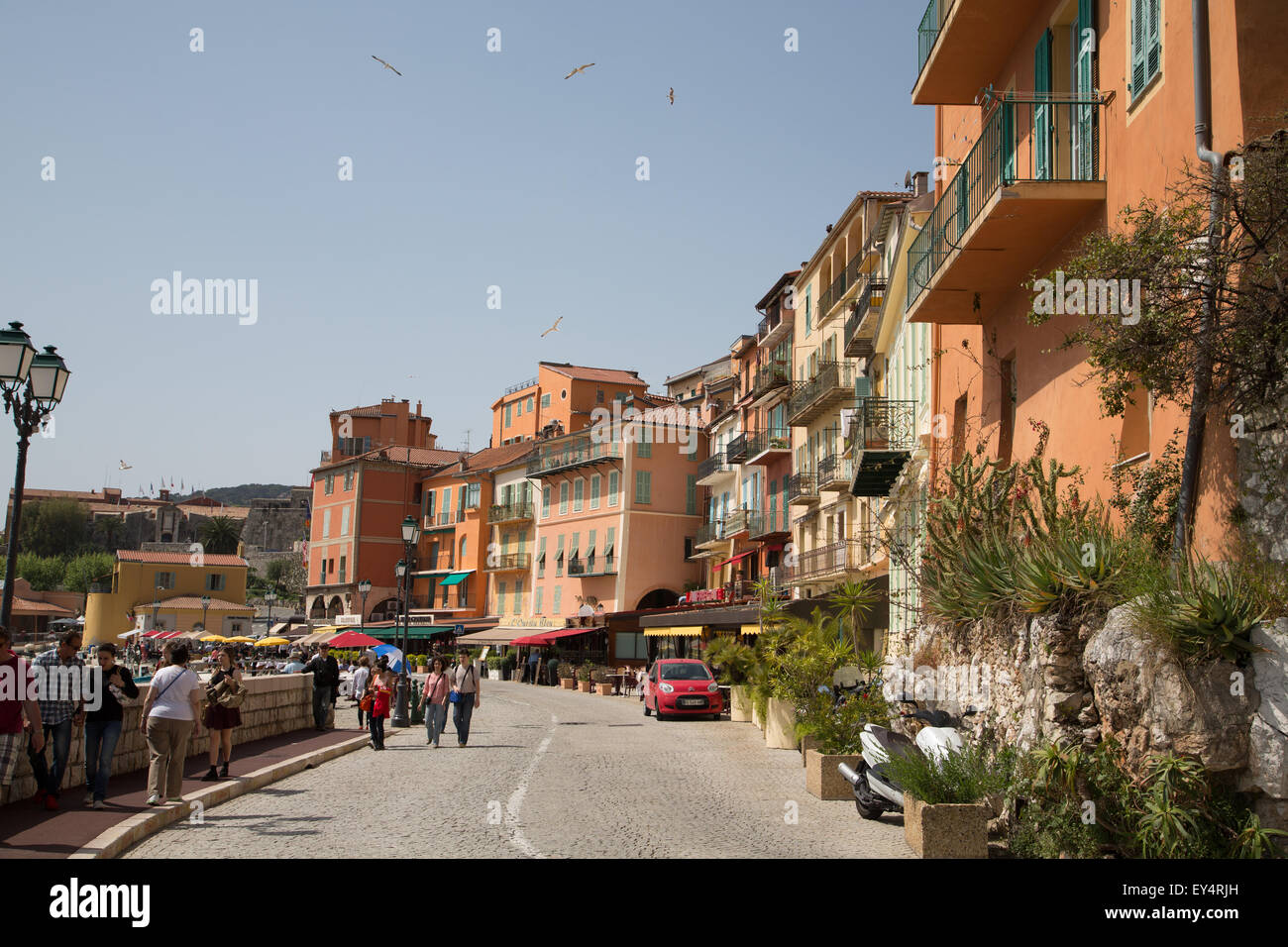 La gente camminare lungo una strada sul mare di Villefranche, Francia Foto Stock