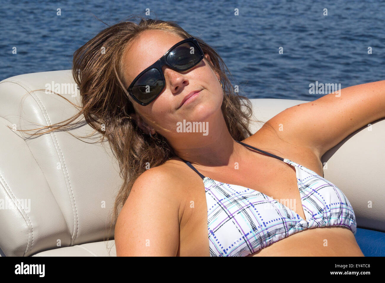 La donna a prendere il sole su una barca Foto Stock