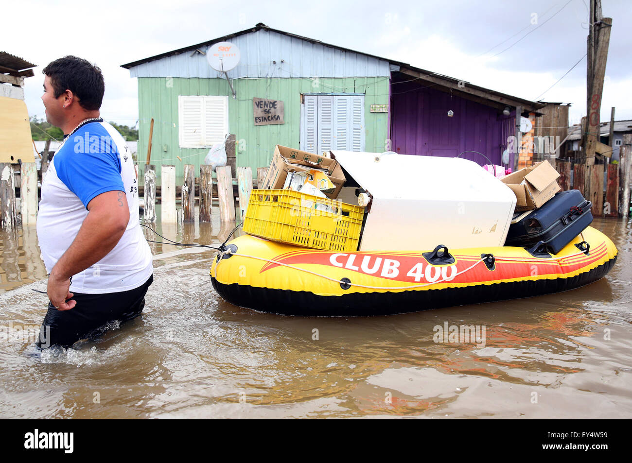 Gravatai, Brasile. 21 Luglio, 2015. Un uomo si muove i suoi beni con un gommone come egli wades attraverso alluvione nella zona di Vila Rica di Gravatai Città, Stato di Rio Grande do Sul, Brasile, il 21 luglio 2015. Più di 50.000 persone sono colpite da forti inondazioni nello stato brasiliano di Rio Grande do Sul, la Regionale di Difesa Civile detto martedì. Credito: Pedro H. Tesch/undici/AGENCIA ESTADO/Xinhua/Alamy Live News Foto Stock