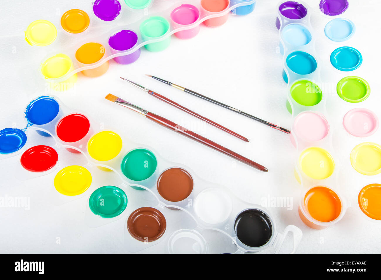 Pennelli e vernice di vari colori in contenitori . Foto Stock