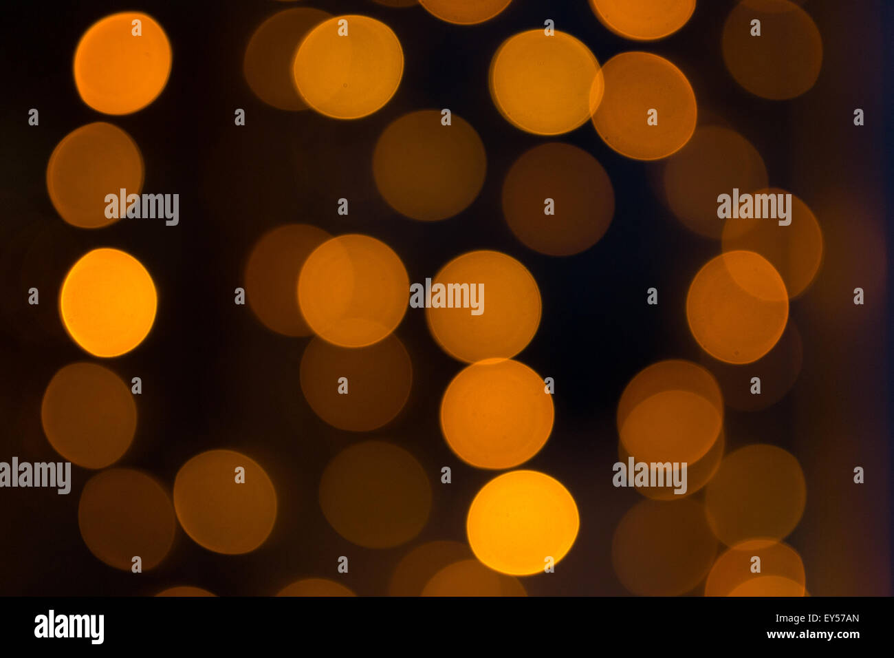 Scintillante di luci di colore arancione con un buio torna sfondo usando un defocalizzata bokeh di fondo tecnica di stile Foto Stock