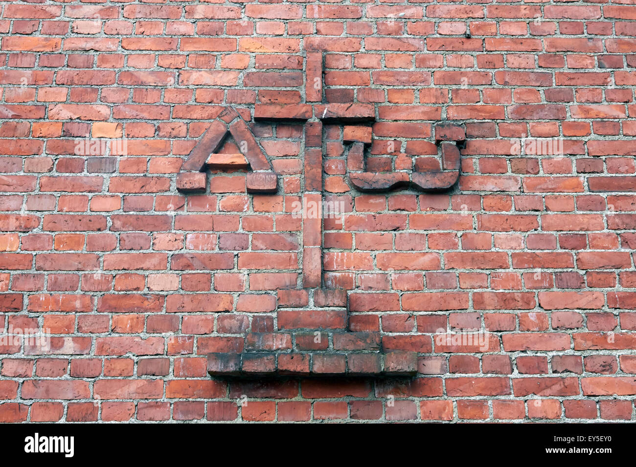 Christian croce di colore rosso sul muro di mattoni Foto Stock