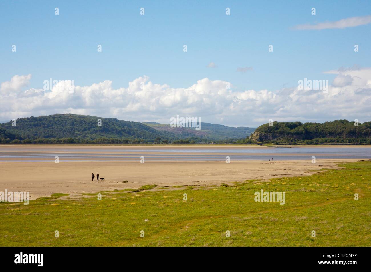 I camminatori sulle sabbie della baia di Morecambe situata a Arnside, Cumbria, guardando verso il lago di distretto colline Foto Stock