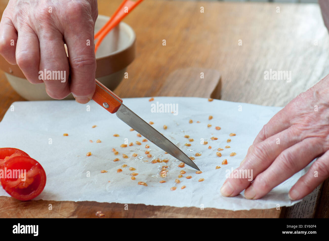 Raccolto di semi di pomodoro gettare semi di pomodoro con coltello Foto Stock