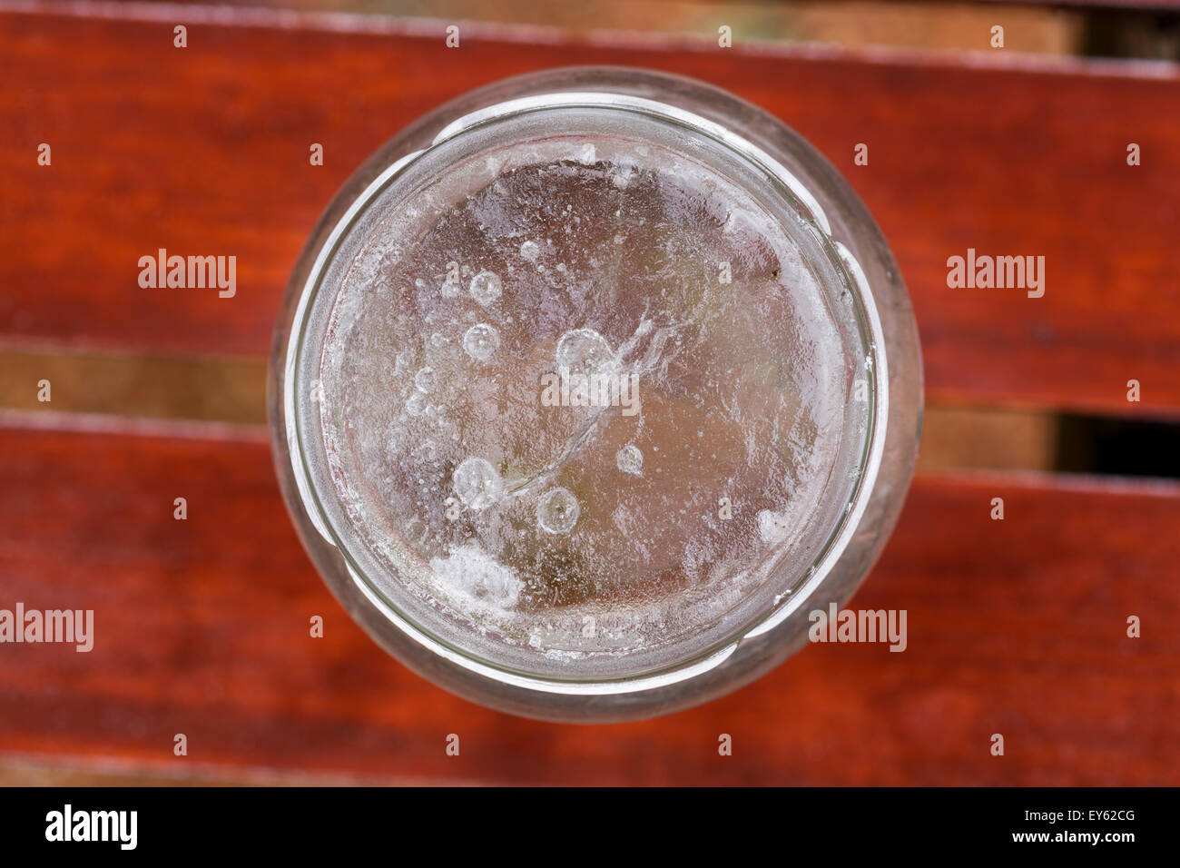 Un vaso di vetro riempito con acqua congelata Foto Stock