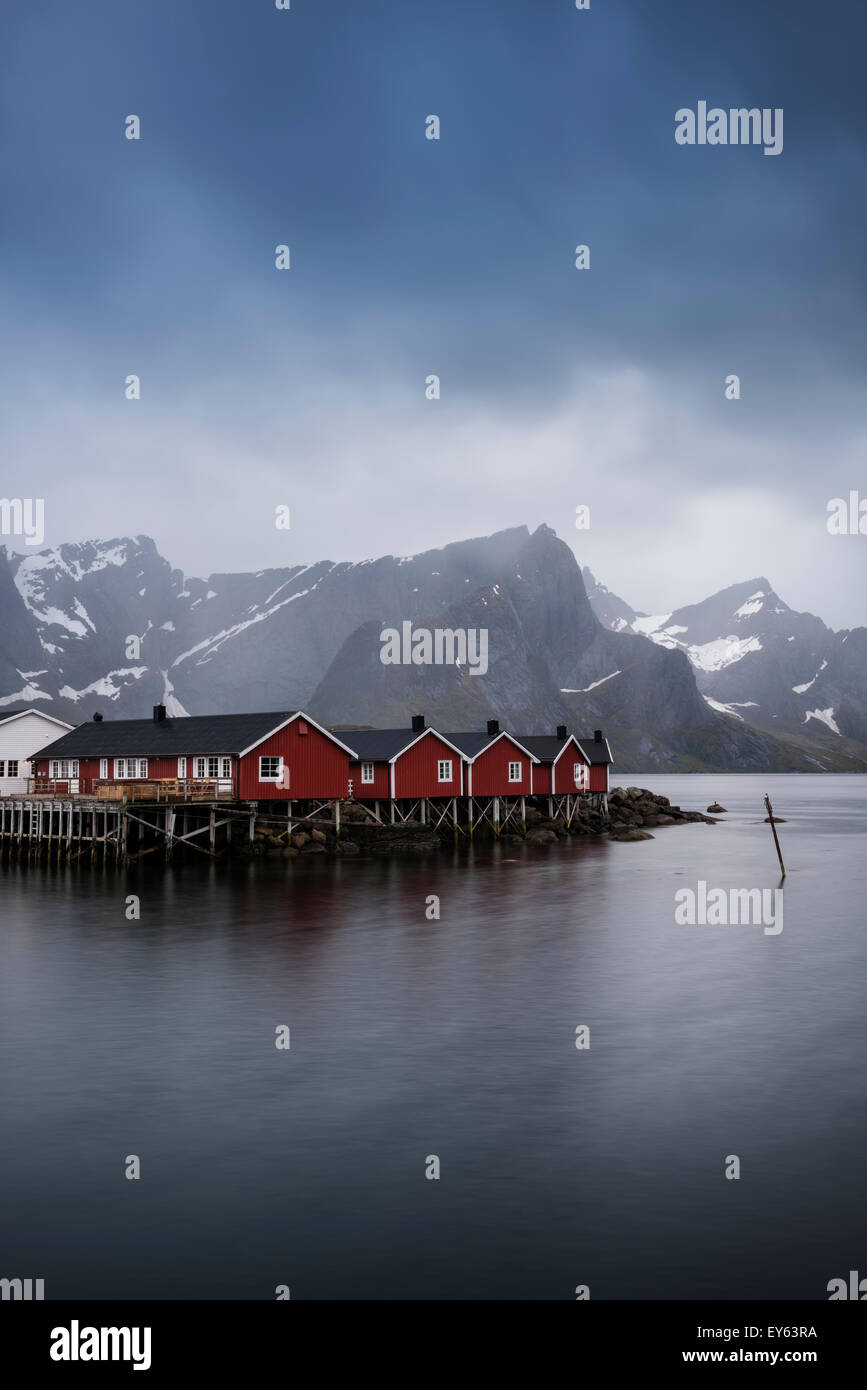 Rosso di pescatori cabine Rorbu sul fiordo, Hamnøy, Reine, Moskenesøy, Isole Lofoten in Norvegia Foto Stock
